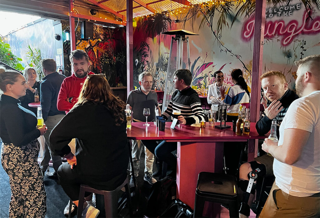 A group of people sit at hightops at a bar patio in San Francisco